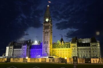 Parliament of Canada illuminated in yellow and blue